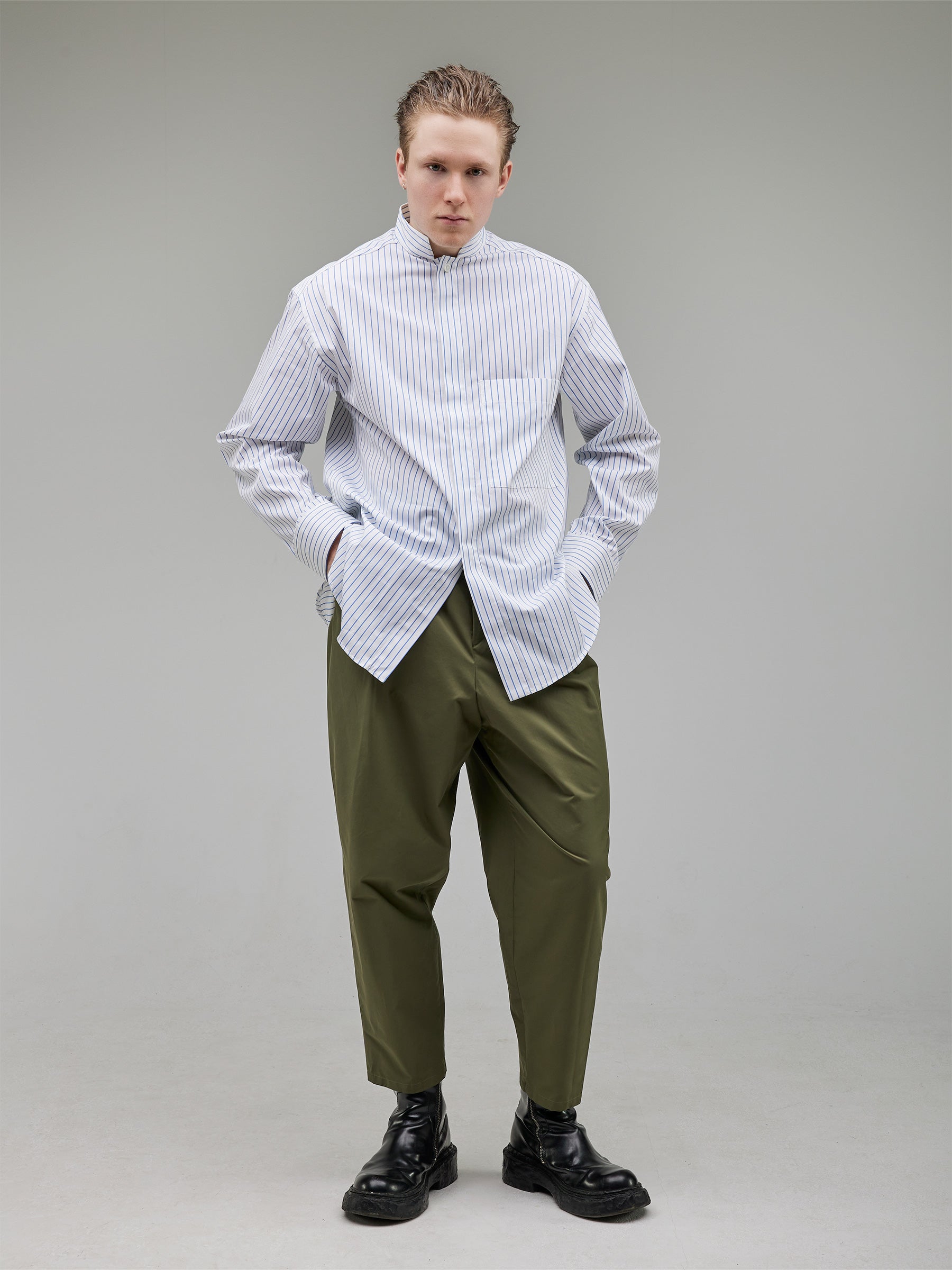 Oversized white and light blue striped mandarin-collar shirt paired with rounded-leg tailored trousers.