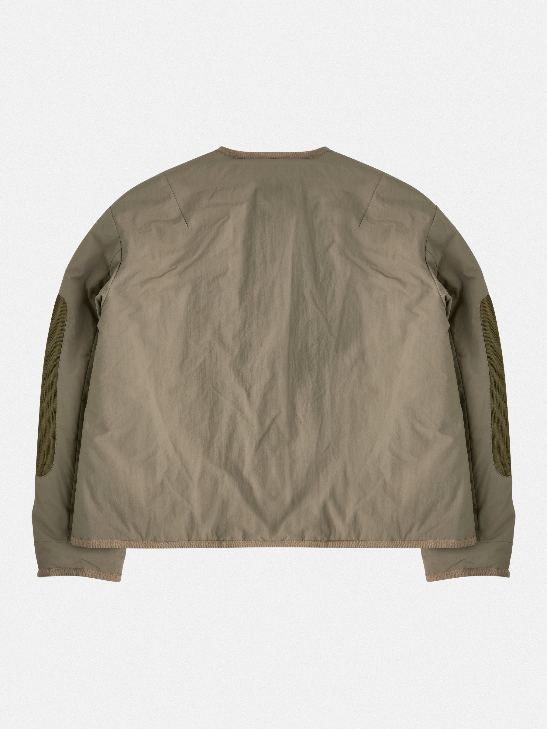 Lightweight insulated liner with a down-like feel, enhanced with mesh elbow details and contrast tape accents. Functional elements include vintage horn button closure and dual zippered lower-arm pockets.
Outer: 100% Recycled Polyamide
Lining: 100% Recycled Polyester (GRS-certified)
Fill: 60% Recycled PET, 40% Polyamide – sustainable down alternative
Details: 100% Recycled Cotton tape trim