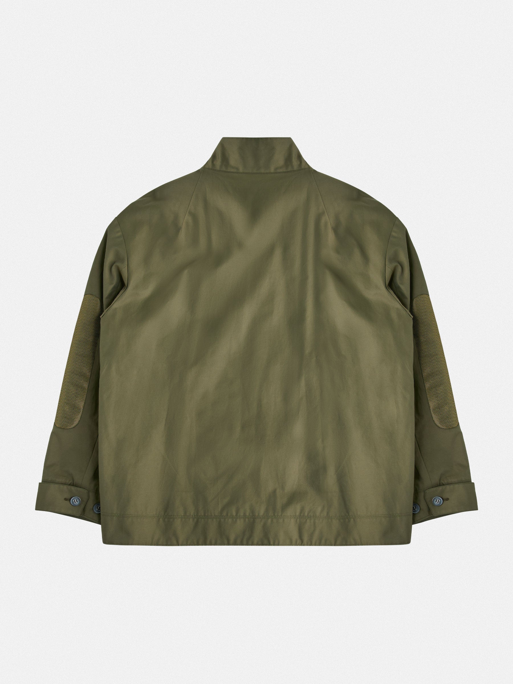 View from behaind of A lightweight technical jacket with dropped shoulders and mesh elbow accents.
Outer: 58% Cotton, 38% Polyamide Gabardine with a light PU finish in army green
Closure: 8mm gunmetal zipper
Styled with an oversized striped mandarin-collar shirt and tapered trousers.