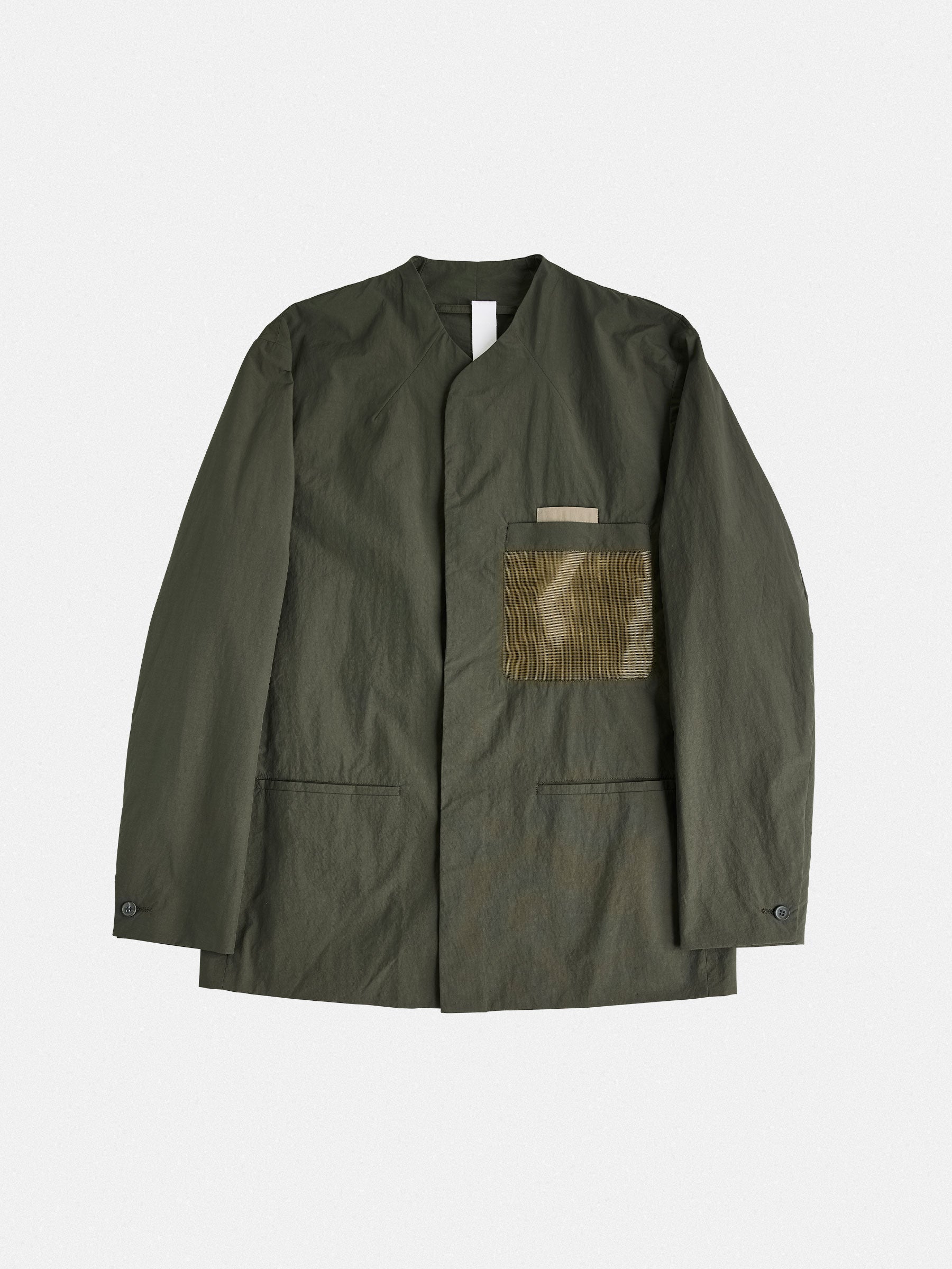 A tailored, collarless blazer with concealed closures and structured contrast chest pockets, balancing minimalism and technical precision.
Shirt: Baby blue striped mandarin-collar shirt, regular fit.