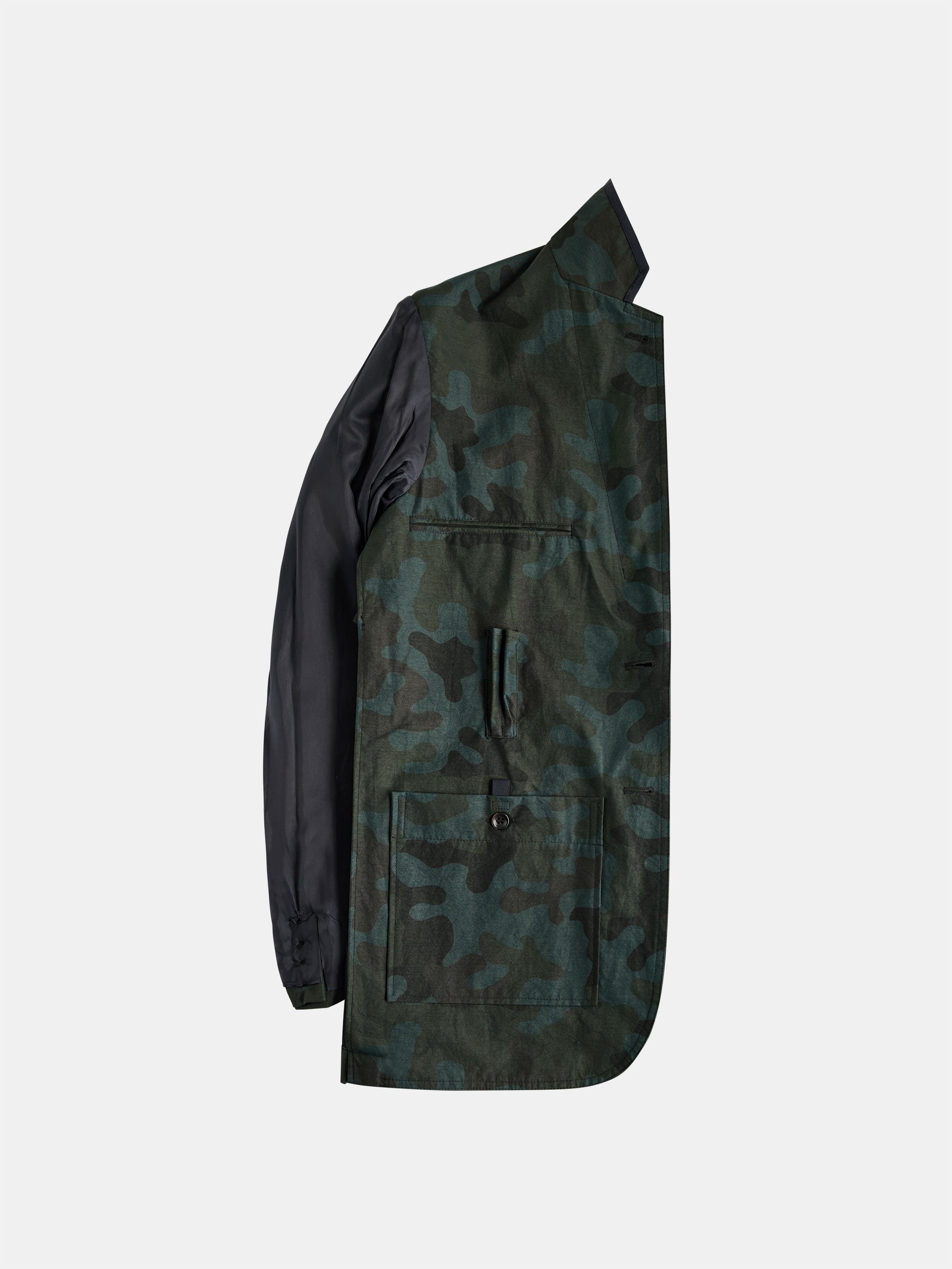 Displayed flat on a light gray background is the gabrielstunz POCKETPARACHUTE® Camouflage Jacket, showcasing its single green and black camouflage design. This packable convenience piece is highlighted by its high collar, button closure, and large front pockets. One sleeve hangs down naturally, completing the look.
